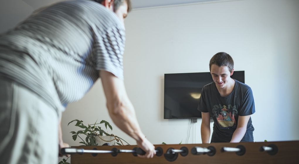 Ein Klient spielt mit einem Unterstützer Tischfussball