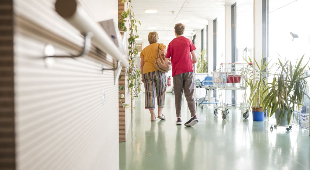 Zwei Menschen in einem hellen Gang mit vielen Pflanzen