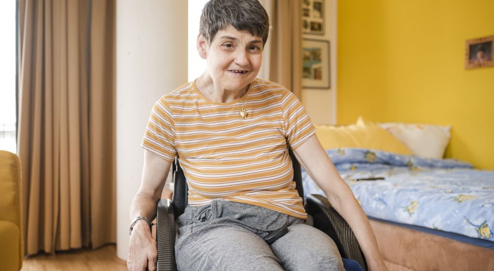 Eine Bewohnerin sitzt im Rollstuhl in ihrem Schlafzimmer
