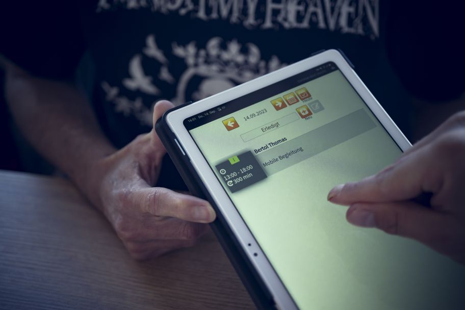 ein Tablet; auf dem Display steht ein Name, Mobile Begleitung