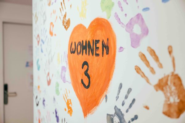 Eine Tür mit der Anschrift Wohnen drei und Handabdrücken