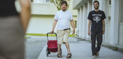 Eine Person begleitet eine andere auf einem Spaziergang im Freien.